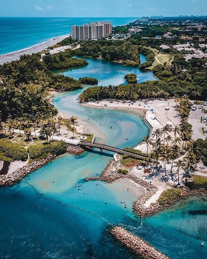 Aerial view of turquoise waterways, beach, and oceanfront homes in Jupiter